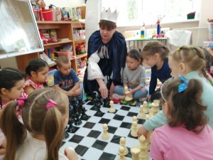 фото дети играют в группе в шахматы с шахматной королевой